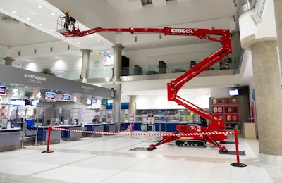 red CMC 65L compact tracked aerial lift outreach in building