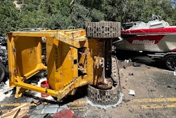 Caterpillar bulldozer laying on its side in the middle of the road