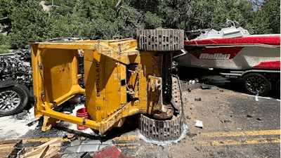 Caterpillar bulldozer laying on its side in the middle of the road