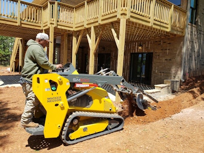 Wacker Neuson SM100 with trencher beside house