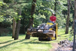 man in red shirt operating wacker neuson SM100 mini track loader carrying logs