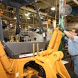 man workers on a machine the CNHI burlington plant