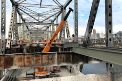 crane repairs a bridge over a river