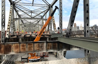 crane repairs a bridge over a river