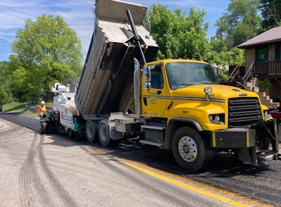 a truck pours asphalt