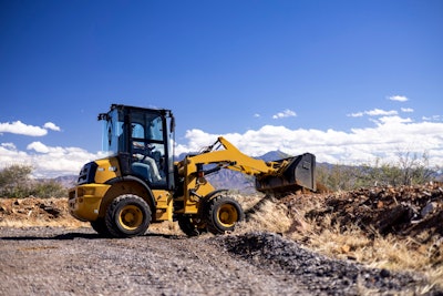 Cat 903 compact wheel loader dumping bucket