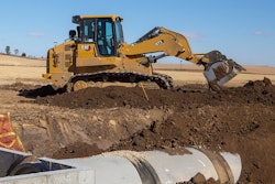 Cat 973 track loader digging near pipe in trench