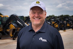 Dennis Howard in front of construction equipment