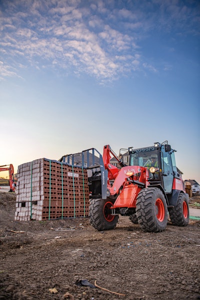 Kubota R640 compact wheel loader carrying bricks