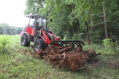 Takeuchi TW60 compact wheel loader pushing brush