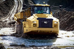 front of cat 745 articulated dump truck running through mud puddle