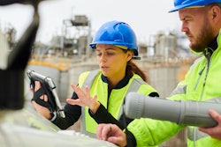 woman man in construction PPE on construction site looking at tablet