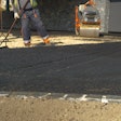 stock image workers raking newly placed asphalt on driveway