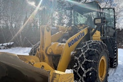 large komatsu wheel loader in snow in maine after being stolen and shot at