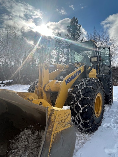 large komatsu wheel loader in snow in maine after being stolen and shot at