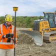Construction worker using Trimble Works technology with a Deere bulldozer