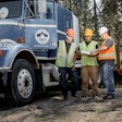 three men work outside a truck