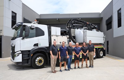men stand in front of a vac truck