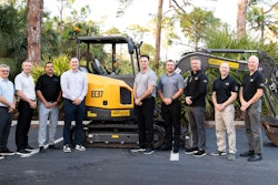 men gathered around a volvo ce compact excavator
