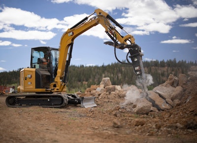 Cat 305CR excavator breaking rock with breaker