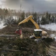 Cat FM528 GF/LL Forestry Excavator with grapple attachment moving logs