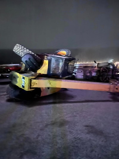 overturned Cat wheeled excavator involved in destroying vehicles