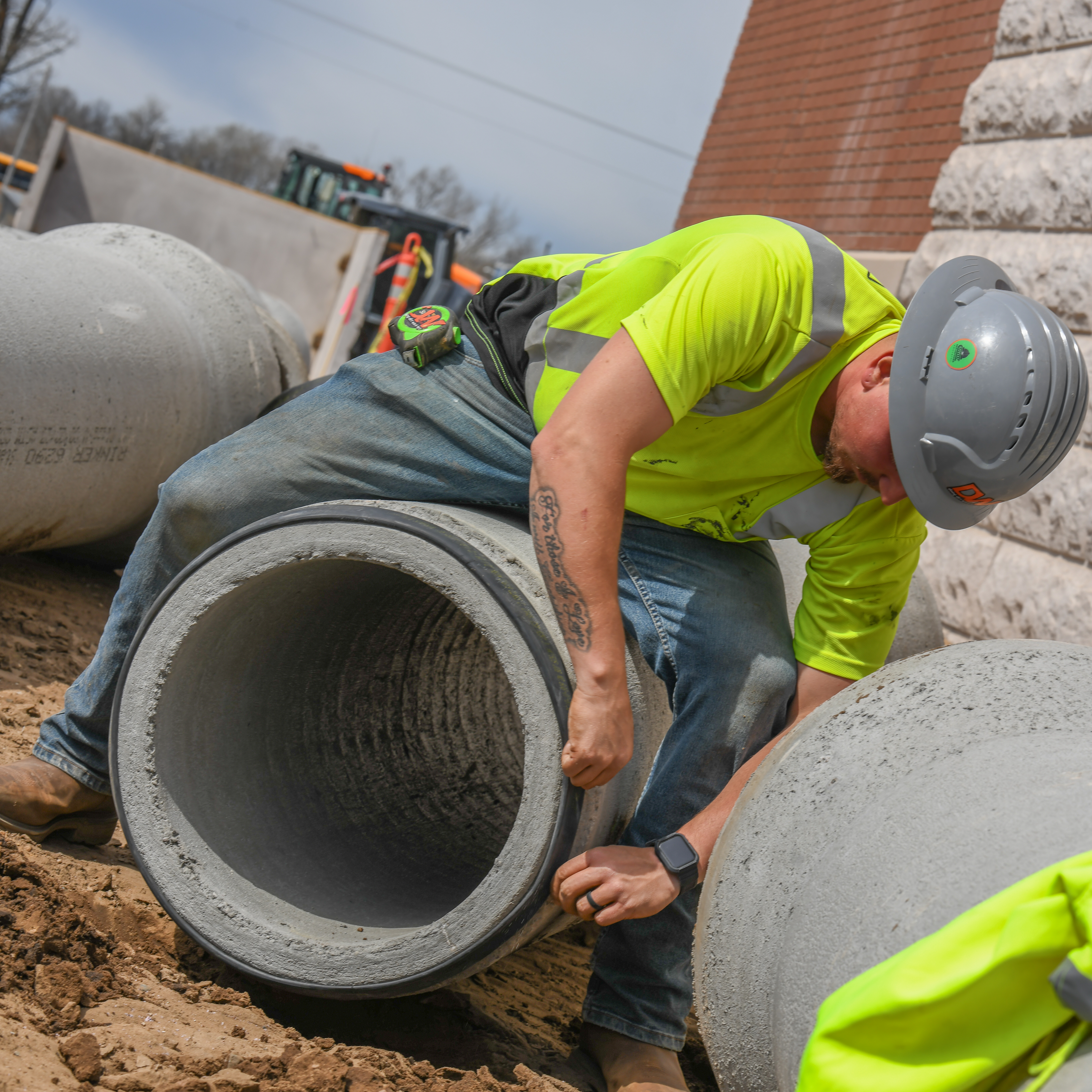 Construction worker applying a seal to a concrete pipe