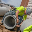 Construction worker applying a seal to a concrete pipe