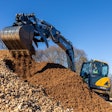 Hyundai HX90A compact excavator dumping dirt
