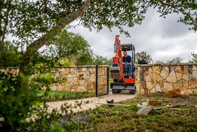 Kubota U17-5 Mini Excavator traveling through Gate on brick wall