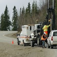 men drill test holes along a road