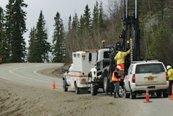men drill test holes along a road