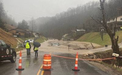 a flooded road between homes in Kentucky
