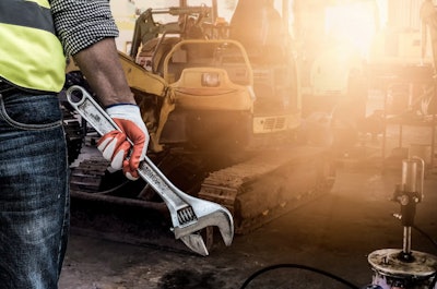 man with a wrench in front of a machine