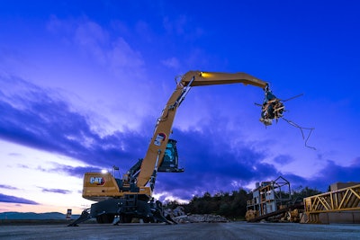 Cat MH3032 Material Handler holing up scrap metal with purplish sky background