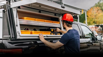 worker orange hard hat pulling toolbox trazer rack on pickup
