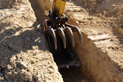 excavator arm digging shallow trench