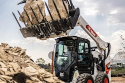 a bobcat skid steer lifting rocks