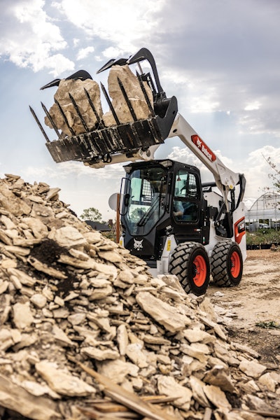 bobcat s86 skid steer rocks in grapple over rock pile