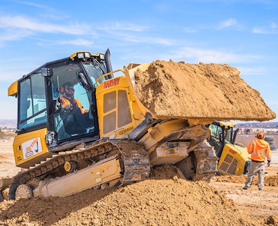 man operates a machine on a stockpile