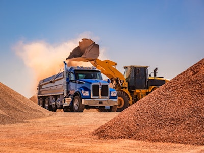 blue kenworth dump truck being loaded with dirt by wheel loader
