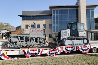 1925 Holt 10-Ton tractor on trailer beside 2025 Cat Centennial Grey D3 dozer