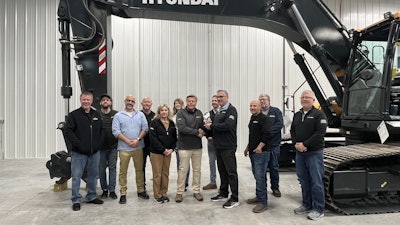Mike Ross, senior VP, HD Hyundai Construction Equipment North America (center right), presents a plaque to Clarence Harding, president and owner of Hardings Inc. (center left), recognizing the dealership’s 20-year milestone as a Hyundai dealer.