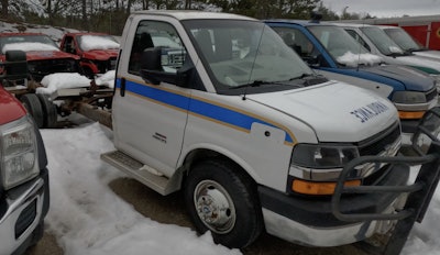 Multiple former ambulances wait behind the shop to be used in future projects.