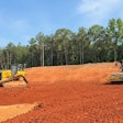 A Bluelight autonomous roller paired with a human-operated dozer on a construction site.