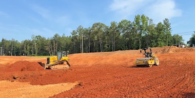 A Bluelight autonomous roller paired with a human-operated dozer on a construction site.