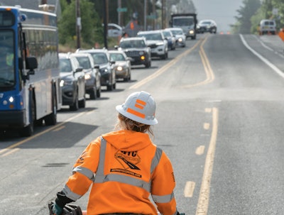 A Western Traffic Control worker directs traffic in Oregon.