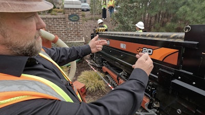Kristopher Kornegay explains the details of an outdoor job drilling and pulling cable at an apartment complex.