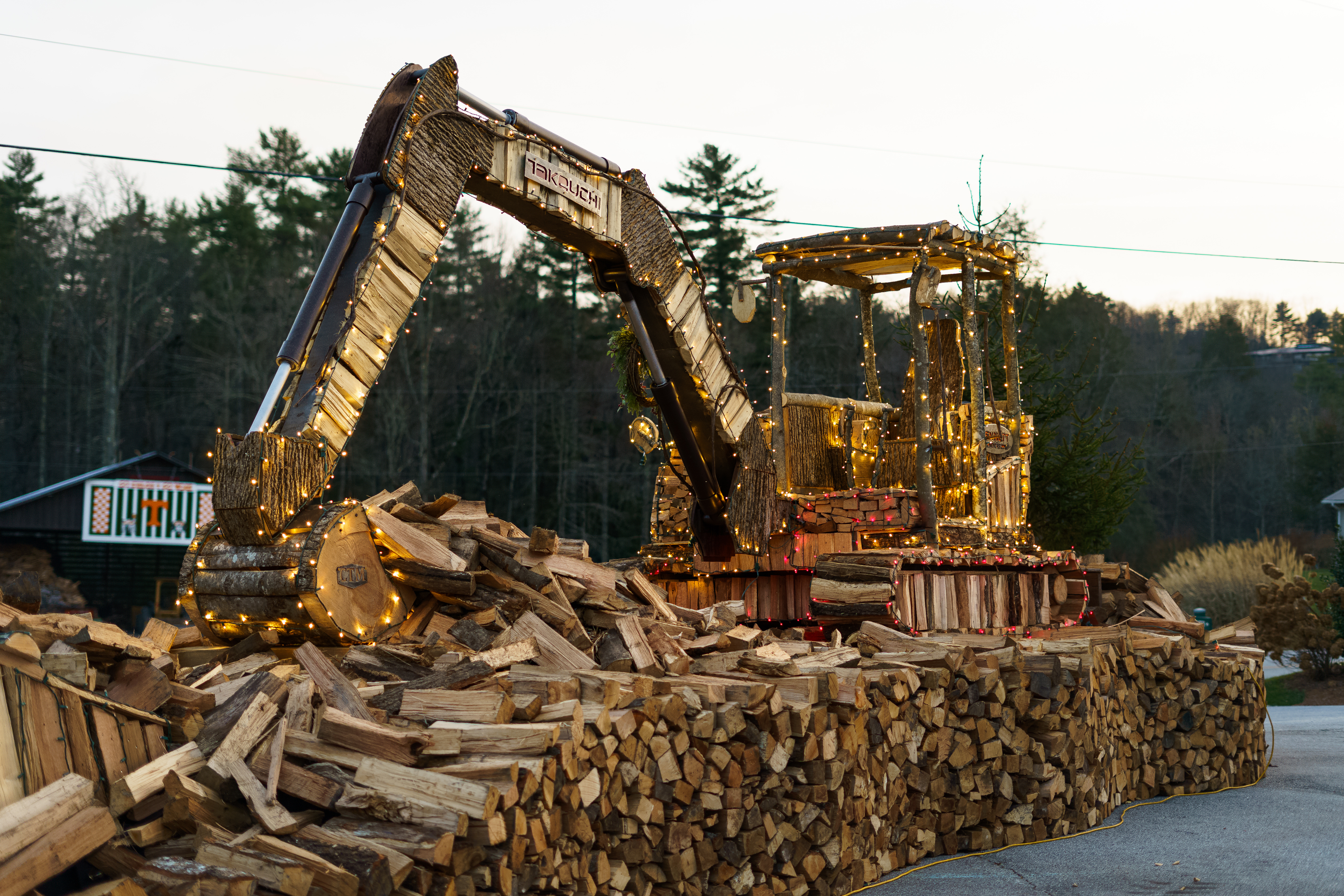 Josh Crawford, owner of Cashiers Firewood, and his team of volunteers made this life-size replica of a Takeuchi TB260 compact excavator out of firewood. He also made a TL10 compact track loader replica.
