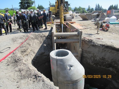 The upright sewer manhole inside the 10-foot-deep trench June 3 with rescuers on the scene after a worker was crushed by a falling excavator bucket in Washington.
